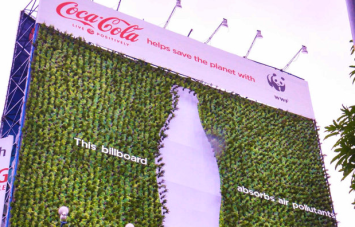 A “living” billboard made of tea plants growing in recycled Coke bottles. Image source.