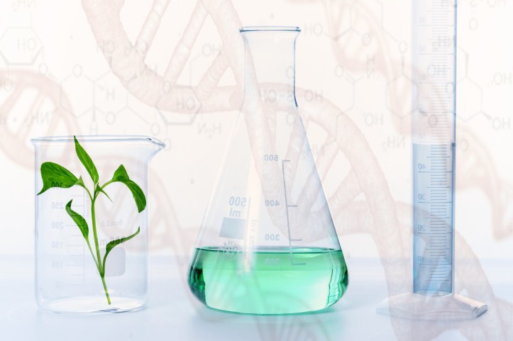 Graphic showing a plant, a flask with green liquid, and a cylinder with blue liquid against a background of cartoon DNA double helices